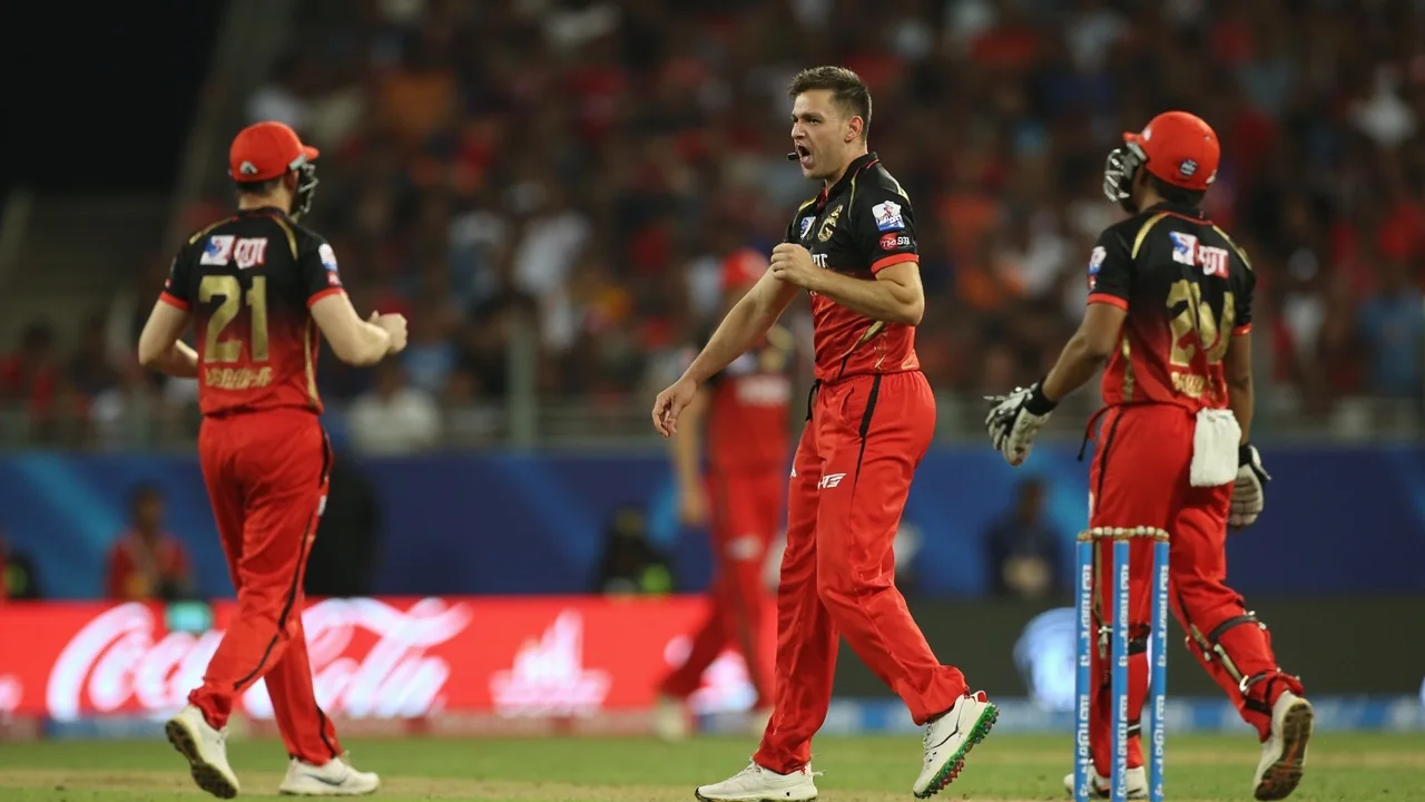 Medium-distance tactical view of field placement and captains conferring at the end of an over during an IPL 2026 evening match